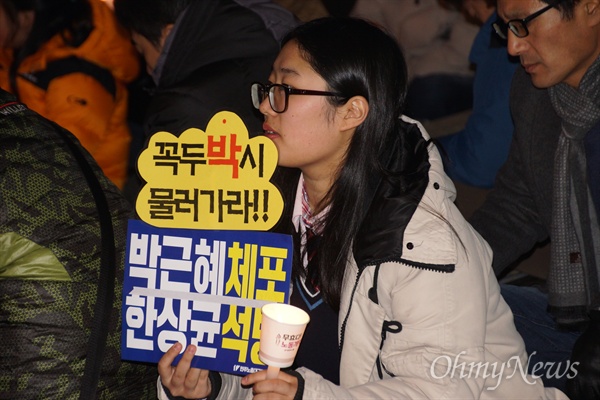 박근혜 대통령의 지역구였던 대구 달성군에서도 7일 오후 시민들이 촛불을 든 가운데 한 참가자가 '꼭두박씨 물러가라'는 손피켓을 들고 앉아 있다.
