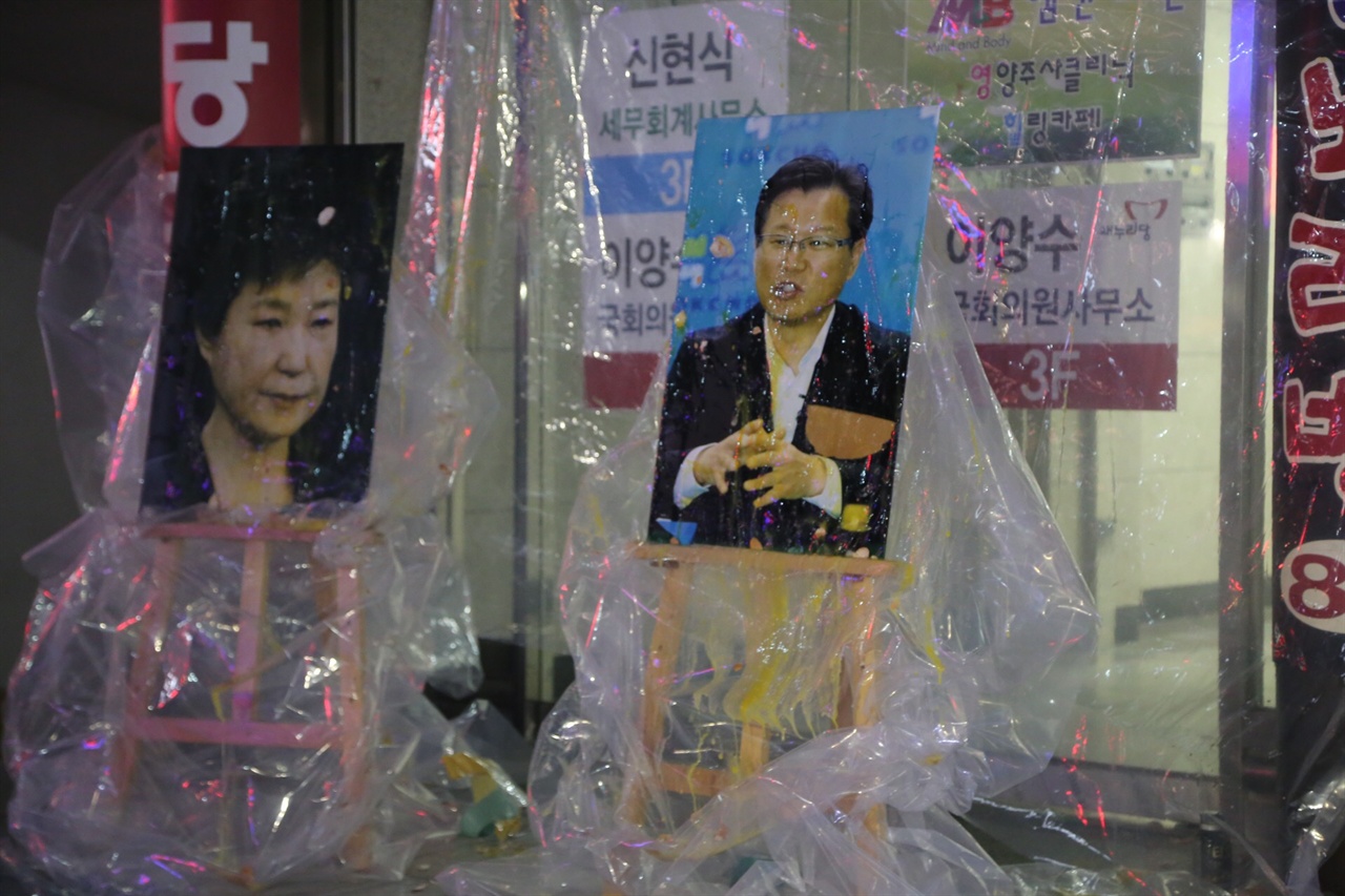 속초 시민들이 이양수의원 사무실 앞에서 박 대통령과 이 의원의 사진에 계란을 던지는 퍼포먼스를 하고 있다.