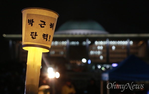 박근혜 대통령의 탄핵소추안 표결 처리를 하루 앞둔 8일 오후 서울 여의도 국회 앞에서 시민들이 모여 박 대통령의 즉각 퇴진과 국정농단의 공범 새누리당 해체를 요구하며 촛불을 밝히고 있다.