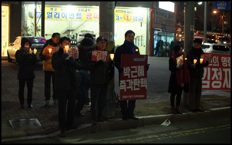 오중기 민주당 경북도당위원장과 당원들이 촛불을 들고 있다.