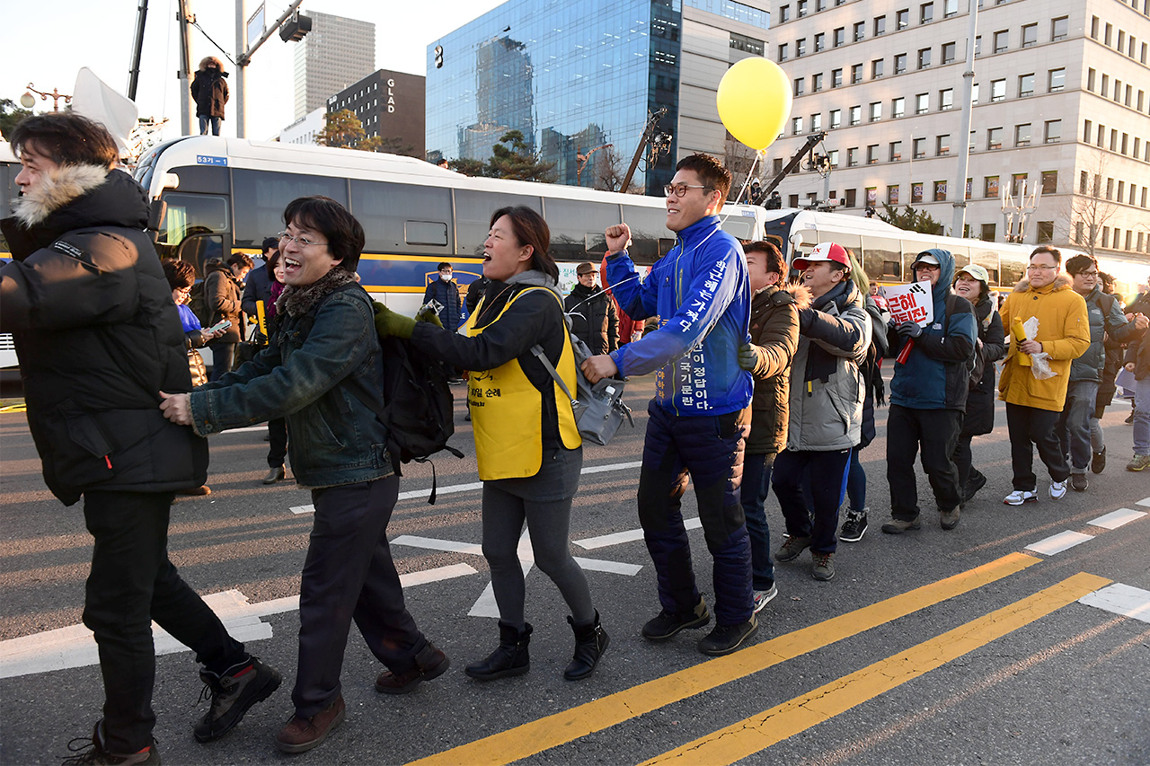 9일 오후 국회 본회의에서 박근혜 대통령에 대한 탄핵안이 통과되자 여의도 국회앞 거리에 모여있던 국민들이 '기차놀이'를 하며 기뻐하고 있다.