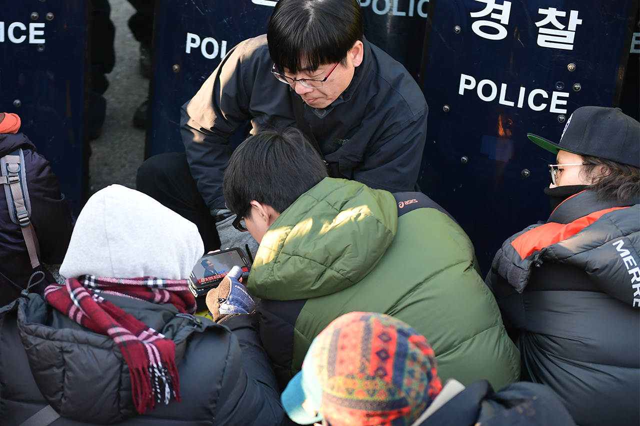 9일 오후 서울 여의도 국회앞에 모인 국민들이 스마트폰을 이용해 국회 본회의 진행상황을 지켜보며 박근혜 대통령에 대한 탄핵안에 대한 개표 결과를 기다리고 있다.