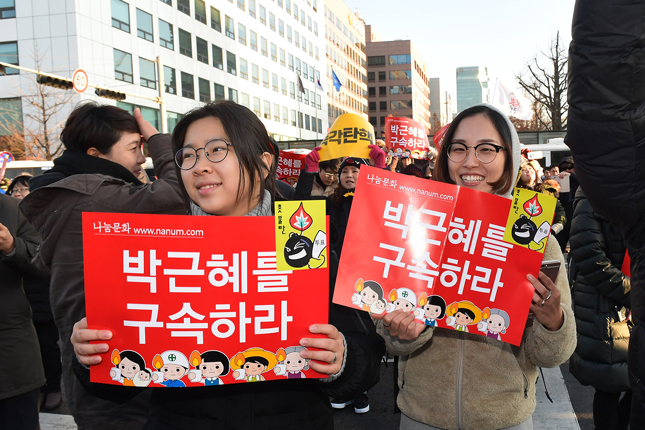 9일 오후 국회 본회의에서 박근혜 대통령에 대한 탄핵안이 통과되자 여의도 국회앞 거리에 모여있던 국민들이 환학 웃으며 기뻐하고 있다.