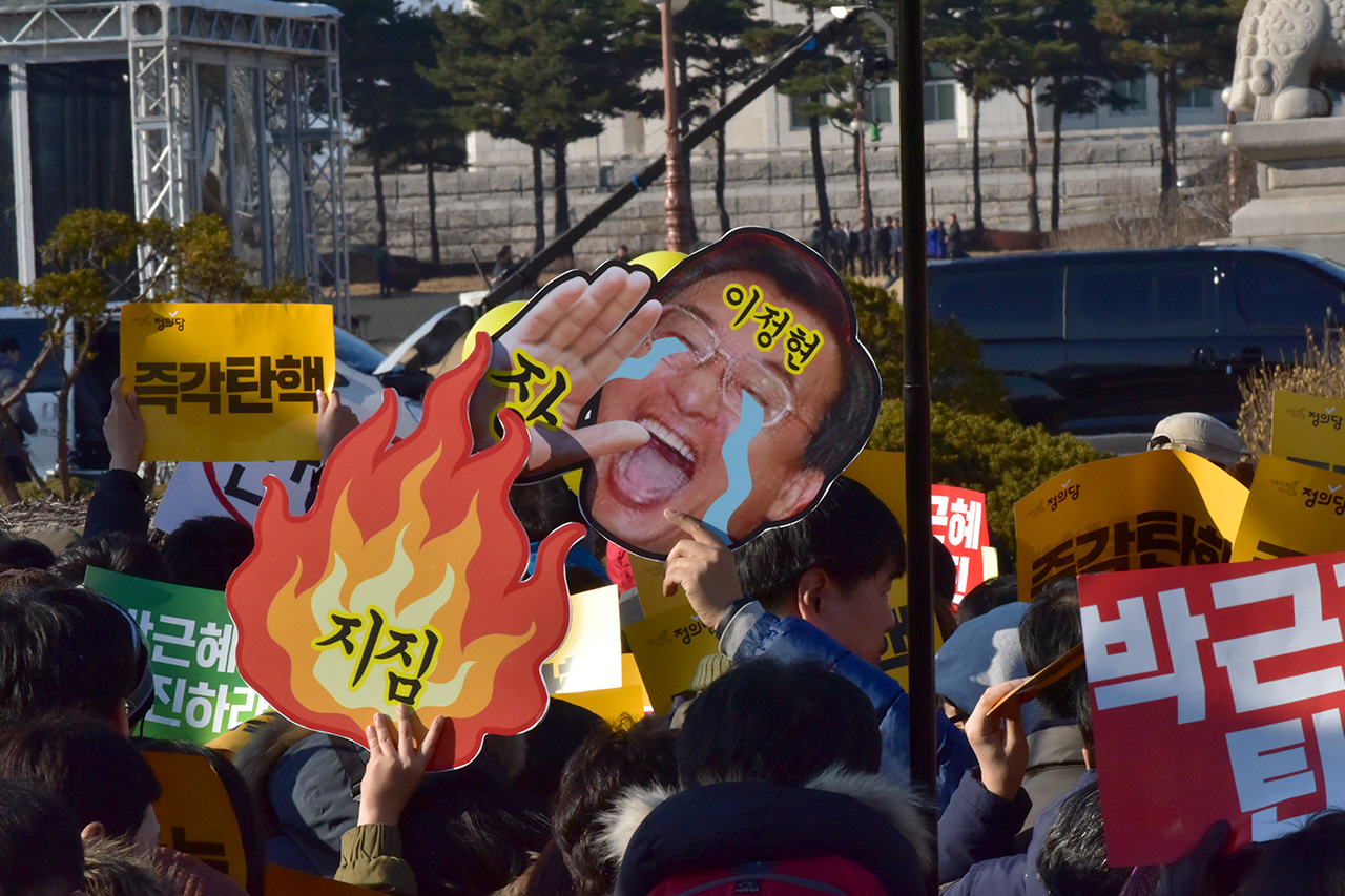 9일 오후 국회 본회의에서 박근혜 대통령에 대한 탄핵안이 통과되자 여의도 국회앞 거리에 모여있던 국민들이 '박근혜 대통령 탄핵을 축하합니다'라는 문구가 쓰여진 현수막앞에서 기념사진을 찍고 있다.