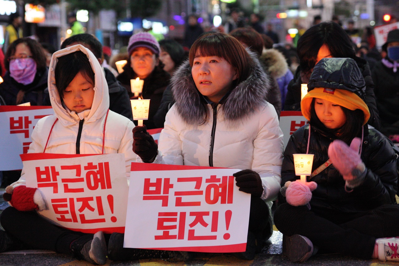 아이들과 촛불집회에 참석한 가족이 박근혜 퇴진 피켓을 펼친 모습