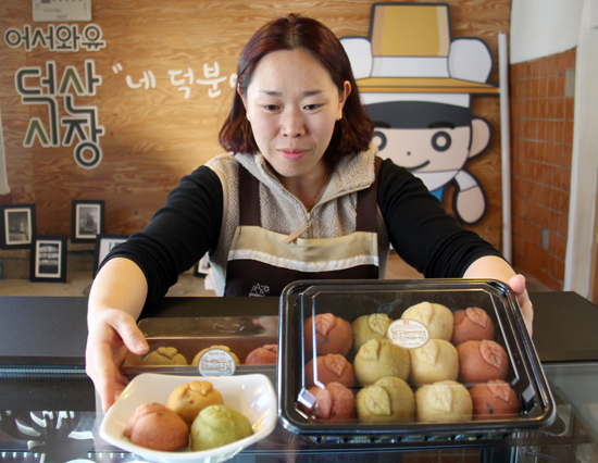 덕산매장 매니저 현종숙씨가 사과빵을 보여주고 있다.