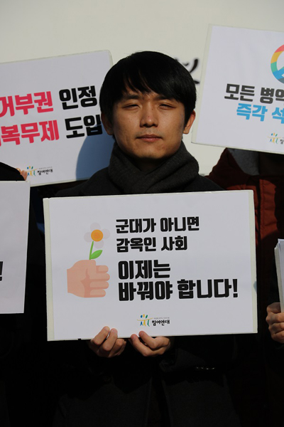 홍정훈 참여연대 활동가가 병역거부를 선언하고 피켓을 들여보이고 있다.