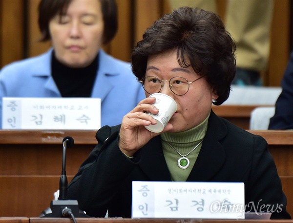 2016년 12월 15일 김경숙 전 이화여자대학교 체육대학장이 국회에서 열린 '박근혜 정부의 최순실 등 민간인에 의한 국정농단 의혹사건 진상규명을 위한 국정조사 특별위원회' 4차 청문회에 출석해 물을 마시고 있다.