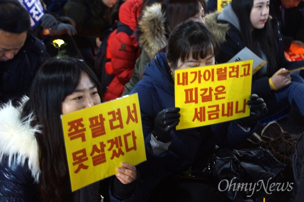 17일 오후 대구 중앙로에서 열린 박근혜 퇴진 시국대회에 참가한 시민들이 손피켓을 들고 앉아 있다.