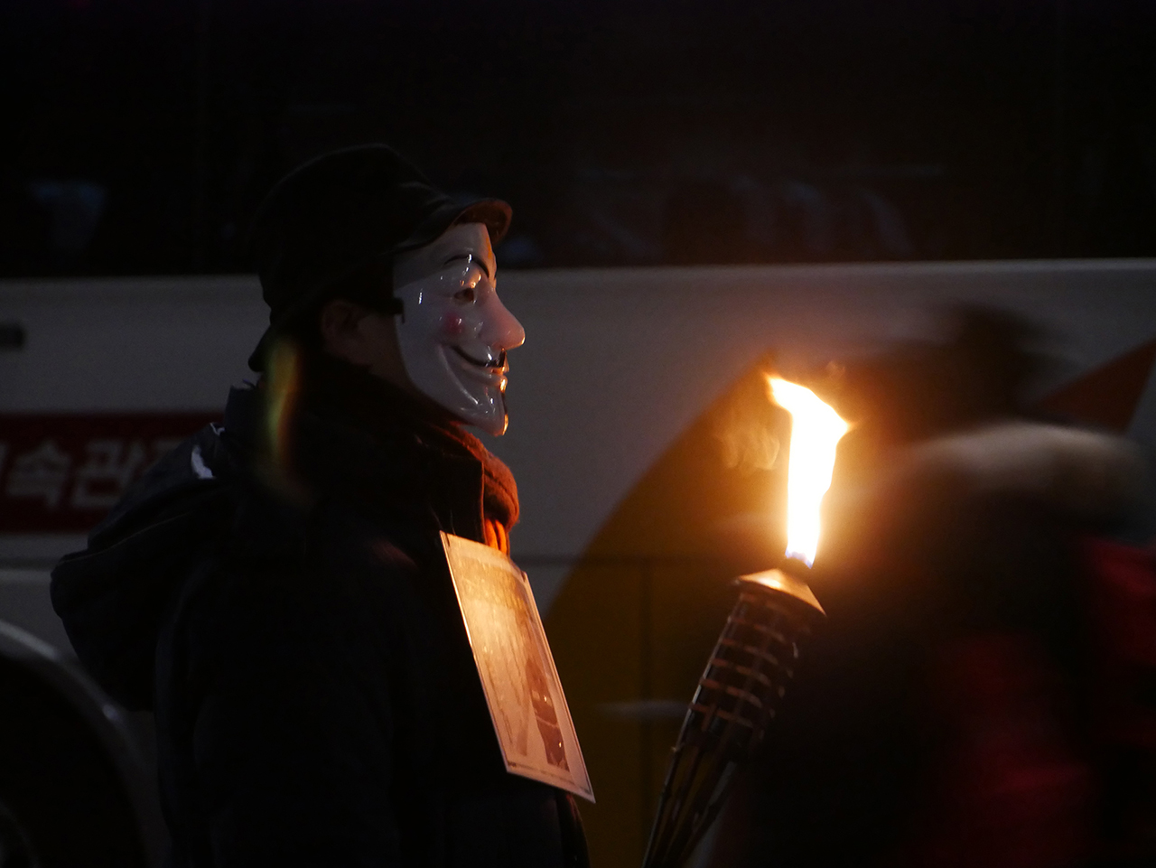 한 시민이 가이포크스 가면을 쓰고 시위를 하고있다