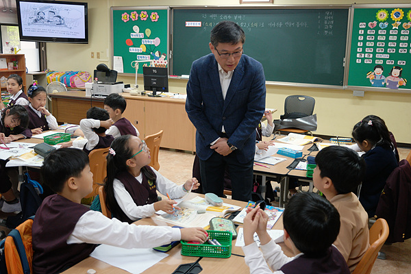  최영대교사가 학생들이 토론하고 논쟁하는 동안 결론을 도출하도록 도와주고 있다 