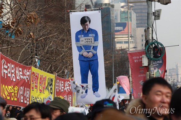 포승줄로 묶인 손석희 JTBC 사장 사진을 제작해서 행진하고 있는 우익 단체 집회 참가자들.