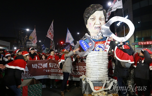 박근혜정권퇴진청년행동 소속 학생들이 24일 오후 서울 종로구 광화문광장에서 열린 '끝까지 간다! 박근혜 즉각 퇴진·조기 탄핵·적폐 청산-9차 촛불집회'를 마친 뒤 박 대통령의 구속수사를 촉구하며 수갑을 선물하는 퍼포먼스를 벌이고 있다.