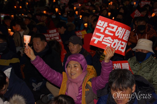 24일 오후 대구시 중구 중앙로 대중교통전용지구에서 열린 8차 차 시국대회에 참가한 참가자가 '박근혜를 구속하라'는 피켓과 촛불을 들어보이고 있다.