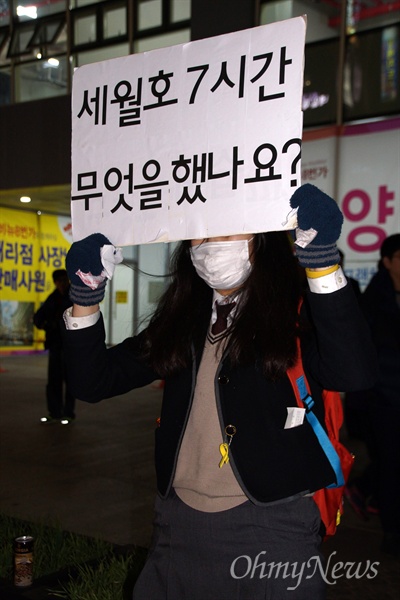 24일 오후 대구에서 열린 박근혜 퇴진 시국대회에 참가한 한 여학생이 교복을 입은 채 '세월호 7시간 무얼 했나요"라고 쓴 손피켓을 들고 서 있다.
