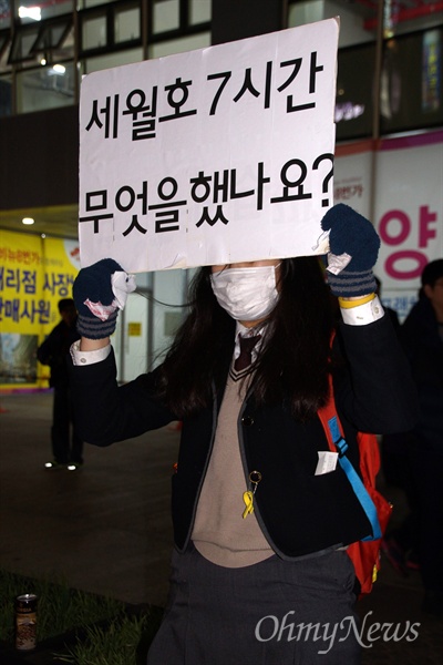  24일 오후 대구에서 열린 박근혜 퇴진 시국대회에 참가한 한 여학생이 교복을 입은 채 '세월호 7시간 무얼 했나요"라고 쓴 손피켓을 들고 서 있다.