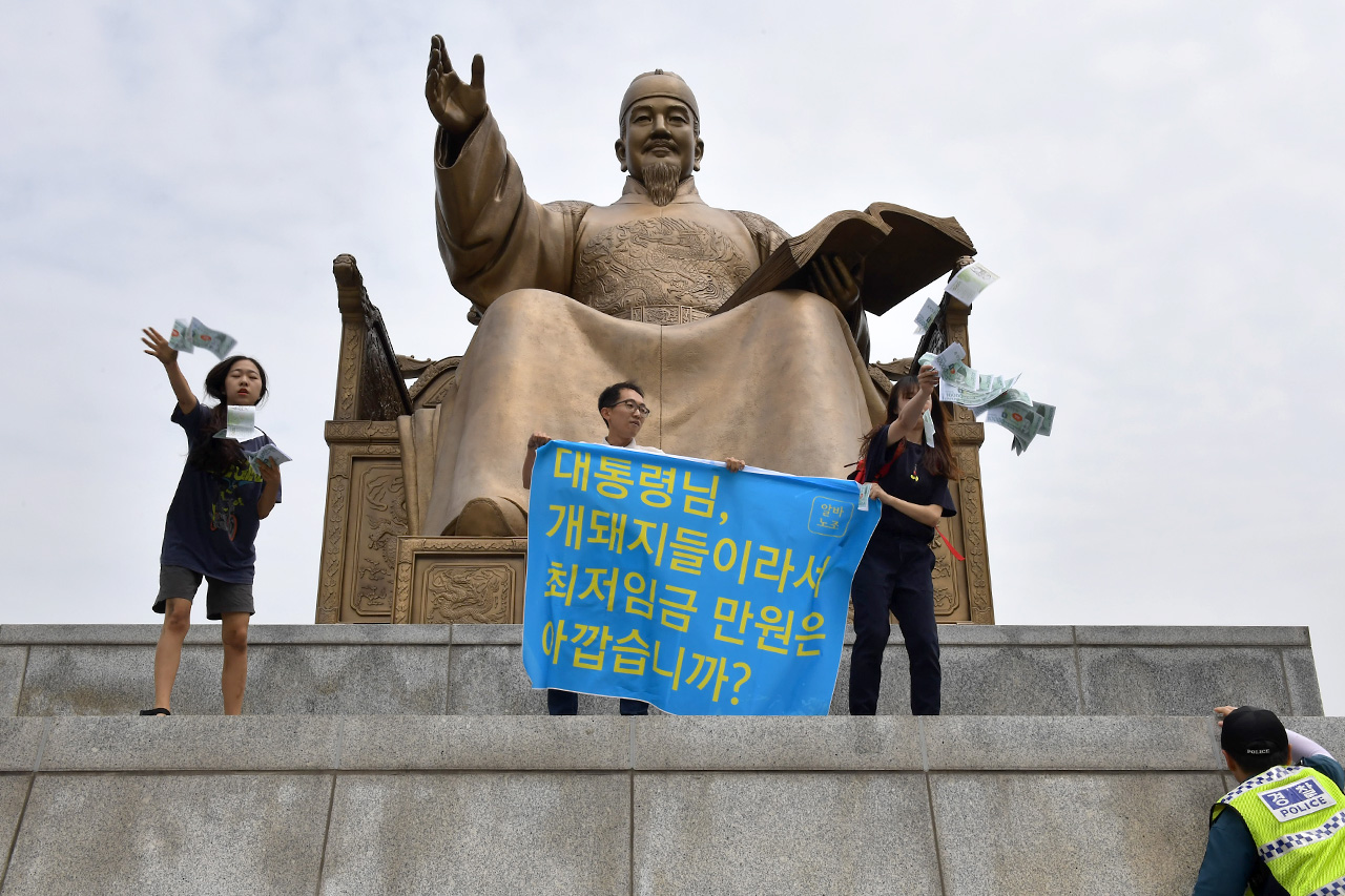 최저임금 1만원으로 지난 7월12일 '알바노조' 관계자들이 '최저임금 1만원 인상'을 요구하며 서울 광화문광장 세종대왕상에 올라가 기습시위를 벌였다.