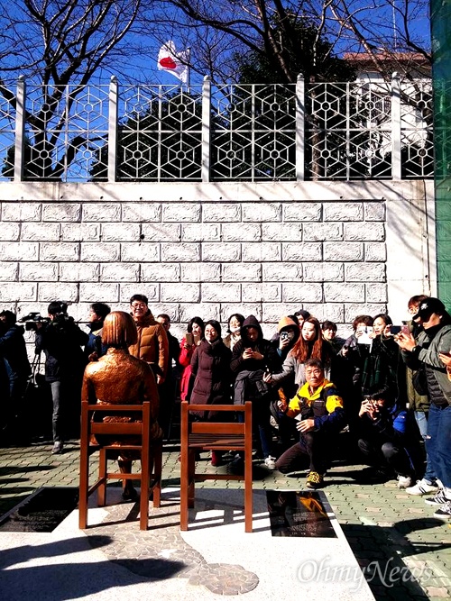 부산동구청으로부터 돌려받은 '평화의 소녀상'은 30일 부산 일본영사관 후문 앞에 다시 세워졌다. 소녀상에서 보면 일장기가 보인다.