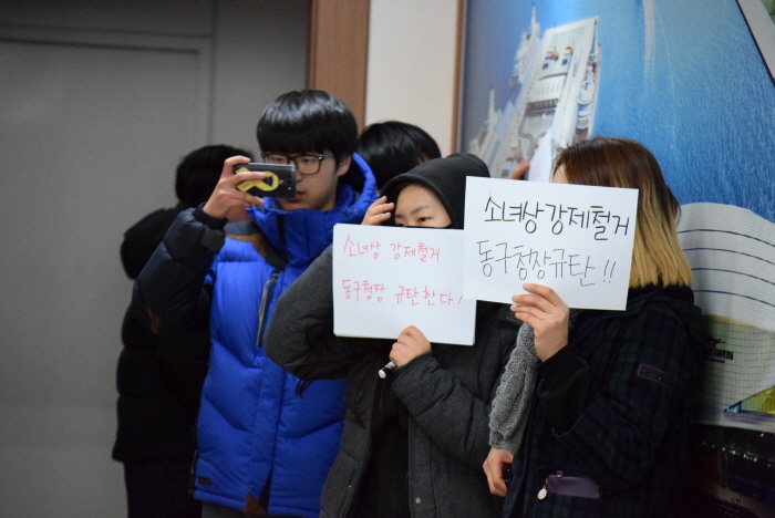 미소추 청소년 회원들이 기자회견장 입구에서 손팻말을 들고 있다.
