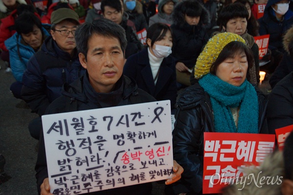 31일 오후 대구 중구 중앙로 대중교통전용지구에서 열린 '#내려와라 박근혜' 대구 시국대회에 참가한 한 참가자가 세월호 7시간을 밝힐 것을 요구하는 피켓을 들고 앉아 있다.