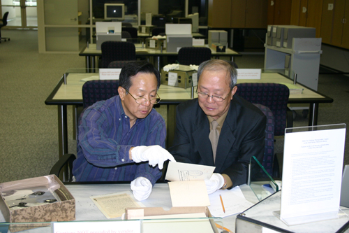 미국 국립문서기록관리청 5층 사진자료실에서 한국전쟁 사진을 앞에 두고 수집여부를 상의하는 박유종(왼쪽) 선생과 기자(2005. 1.)