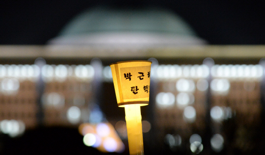 박근혜 대통령 탄핵소추안에 대한 국회의 표결을 앞두고 열린 국회 앞 촛불집회에서 한 시민이 든 '박근혜 탄핵'이라 적힌 촛불.