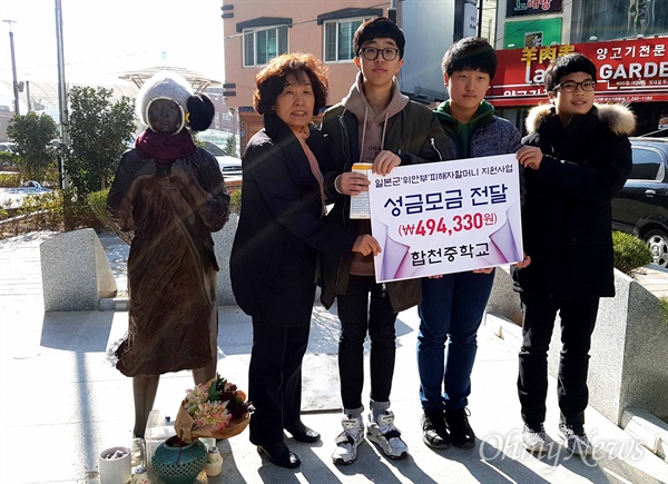  합천중학교 학생들이 3일 창원 오동동문화거리 인권자주평화다짐비에서 이경희 대표한테 성금을 전달했다.