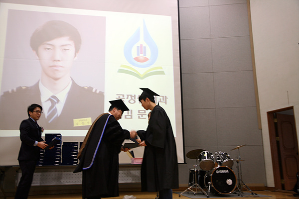 김문성 군이 조영만 교장으로 부터 졸업장을 받고 있다