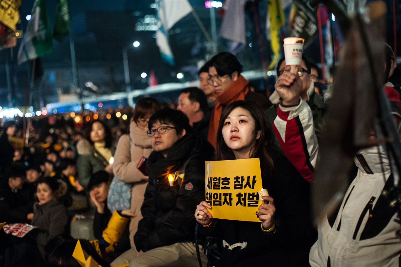 2017년 1월 7일, 광화문 광장의 시민들 세월호 참사 1000일을 이틀 앞둔 1월 7일에는 많은 시민들이 촛불을 들고 광화문 광장에 모였다. 피켓과 촛불을 들고 유가족의 발언을 지켜보고 있는 시민들.