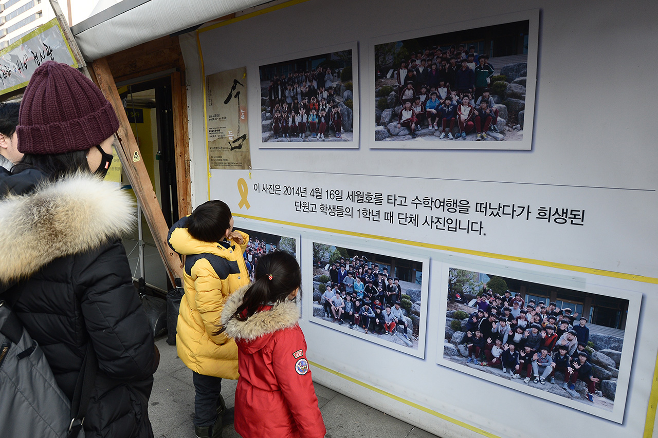 세월호 참사 1000일째를 맞이한 9일 오후 서울 종로구 광화문광장에 마련되어 있는 '세월호 참사 희생자 및 미수습자 광화문 분향소'를 찾은 한 가족이 세월호 참사로 희생된 단원고 학생들의 단체사진을 바라보고 있다.