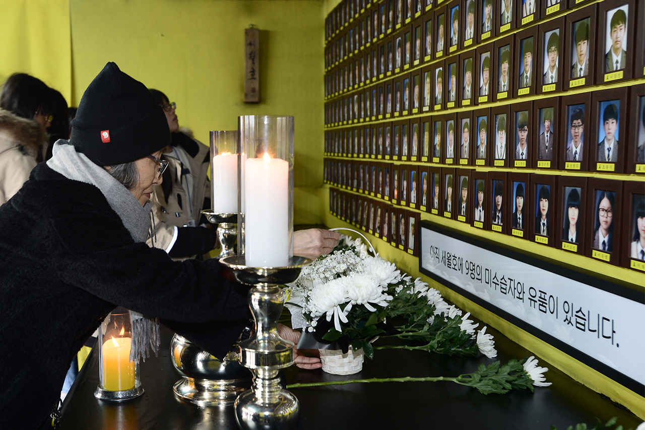 세월호 참사 1000일째를 맞이한 9일 오후 서울 종로구 광화문광장에 마련되어 있는 '세월호 참사 희생자 및 미수습자 광화문 분향소'를 찾은 한 시민이 희생자들의 영정사진앞에 흰국화 바구니를 헌화하고 있다.