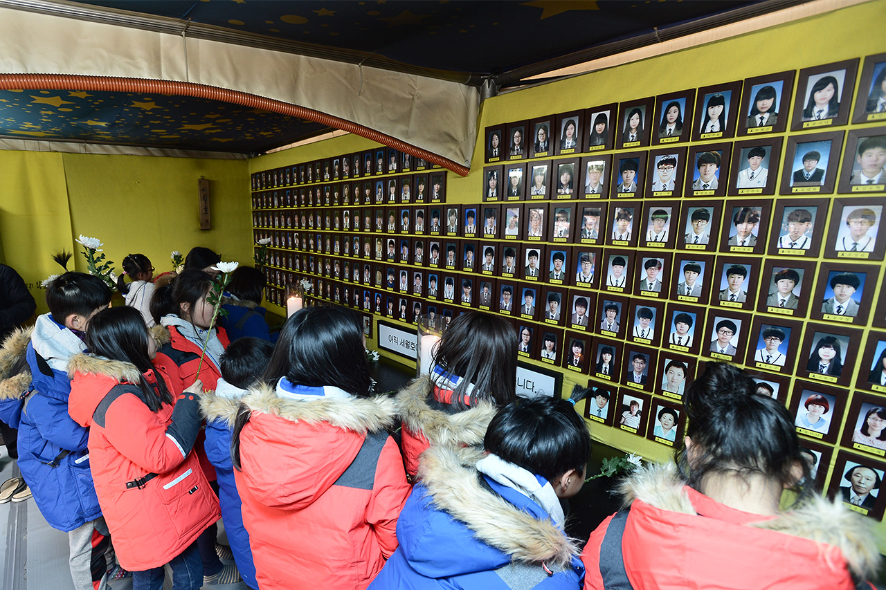 세월호 참사 1000일째를 맞이한 9일 오후 서울 종로구 광화문광장에 마련되어 있는 '세월호 참사 희생자 및 미수습자 광화문 분향소'를 찾은 어린 학생들이 국화꽃을 헌화하고 있다.