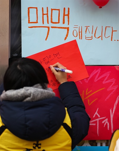 알바노조 조합원들이 10일 오전 서울 마포구 망원동 맥도날드 망원점에서 체불임금 지급을 요구하는 피켓을 매장 전면에 부착하고 있다.