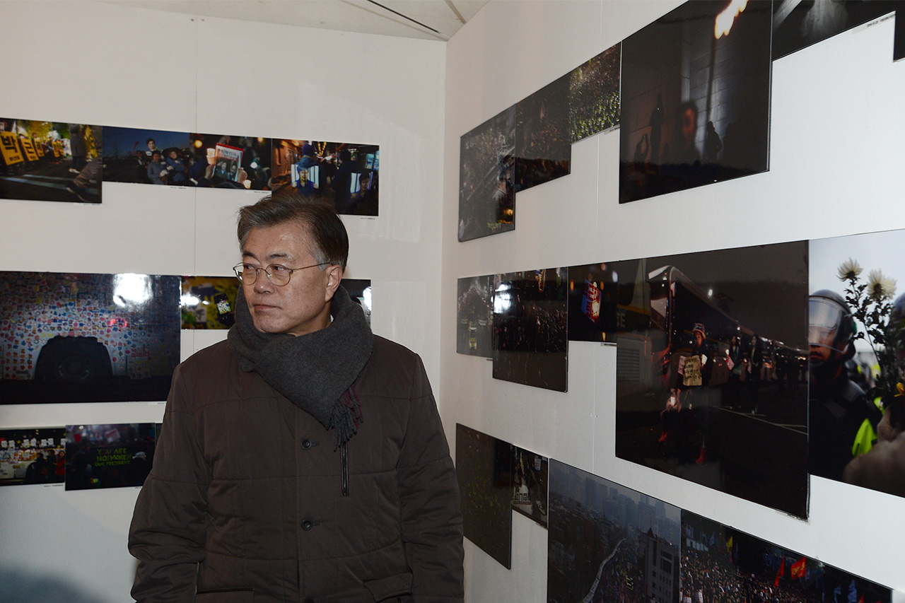  문재인 더불어민주당 전 대표가 14일 오후 서울 종로구 광화문광장에 설치되어 있는 '궁핍현대미술관'에서 열리고있는 '촛불항쟁' 사진전 '어둠은 빛을 이길 수 없다' 전시장을 둘러보고 있다.