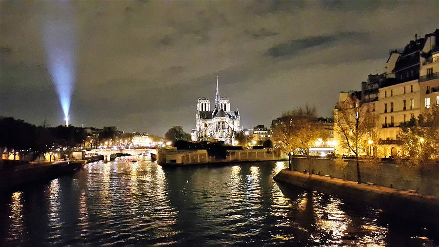 파리 센강 위에 시테 섬. 노틀담 성당의 뒷모습이 보이고 그 뒤로 에펠탑에서 쏘아 올리는 레이저 빔의 불빛이 보인다.