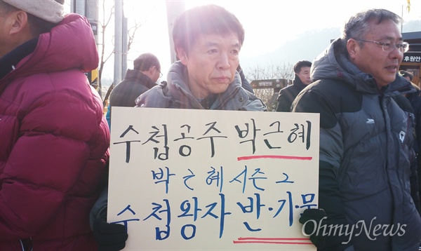 17일 아침, 봉하마을에서 한 시민이 '수첩공주 박근혜, 수첩왕자 반기문'이라고 적힌 피켓을 들고 있다.
