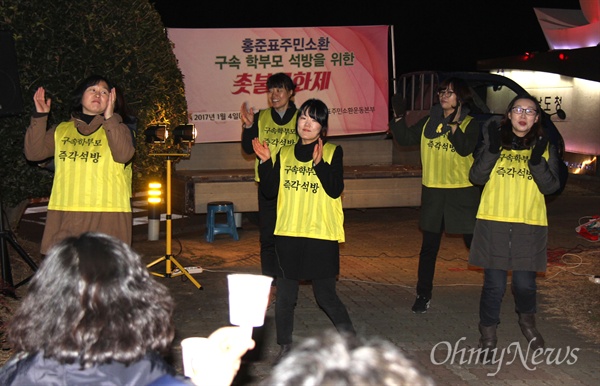 '홍준표 경남지사 주민소환운동본부'가 18일 저녁 경남도청 앞에서 연 '구속 학부모 석방 촉구 촛불문화제'에서 참가자들이 율동공연하고 있다.