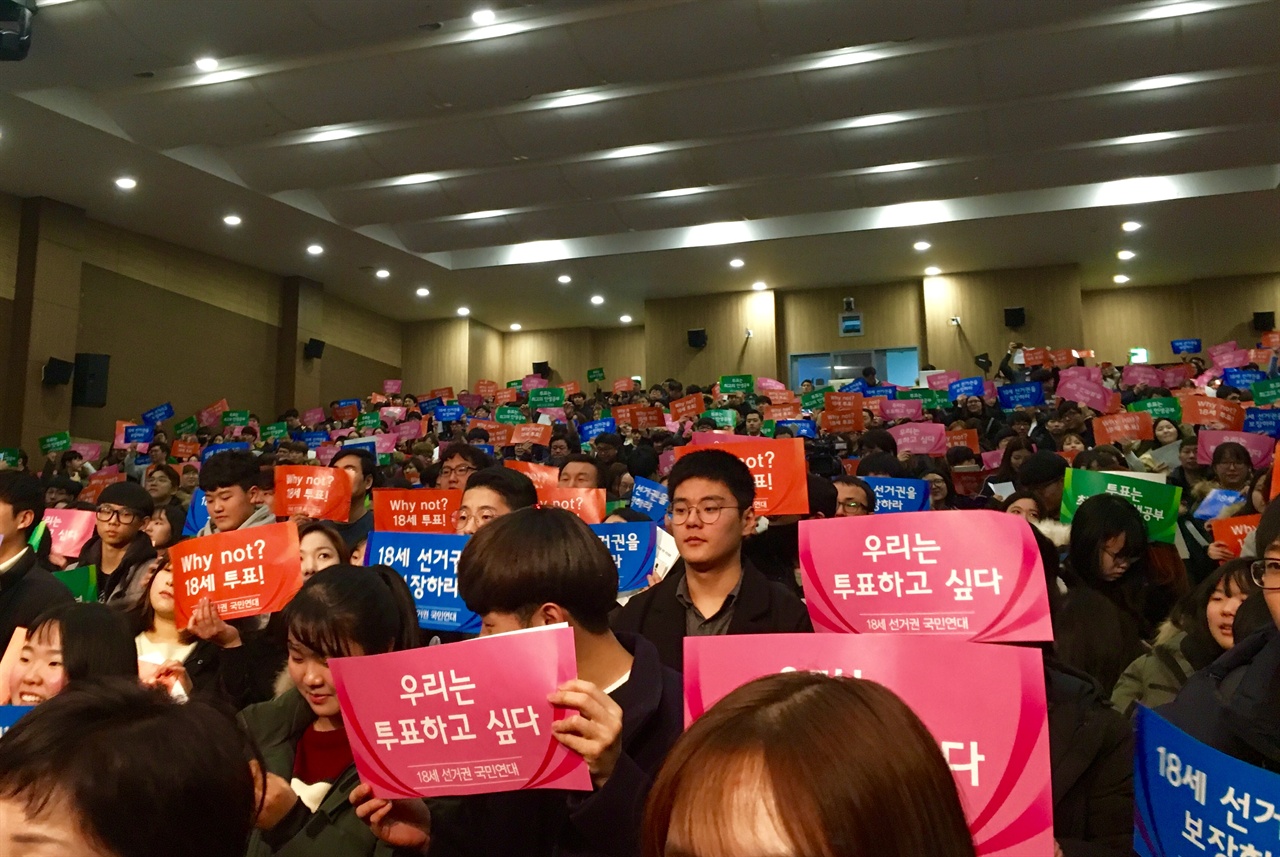 지난달 19일 오전, 18세 선거권 보장을 위한 국민대회가 국회 의원회관 대회의실에서 열렸다. 대회의실에 가득 찬 사람들이 손피켓을 들고있다