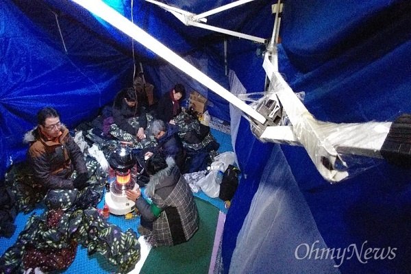 21일 새벽 '이재용 삼성전자 부회장의 구속영장 기각'에 대해 규탄하는 법률가들이 경찰기동대가 난입해 훼손된 텐트를 임시로 고쳐 농성을 이어가고 있다.