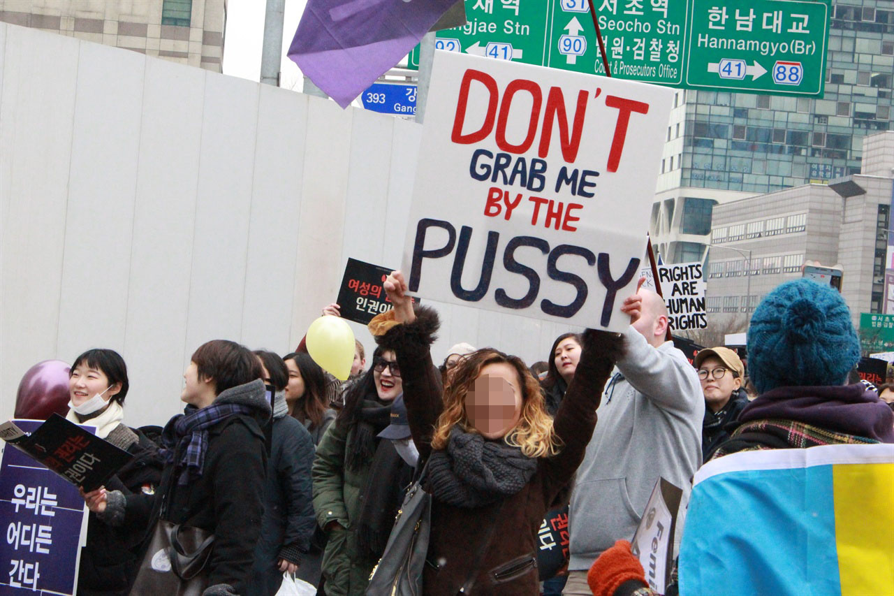 21일 강남역에서 진행된 '세계 여성 공동행진'의 참가자가 "Don't grab me by the pussy" 피켓을 들고 있다.