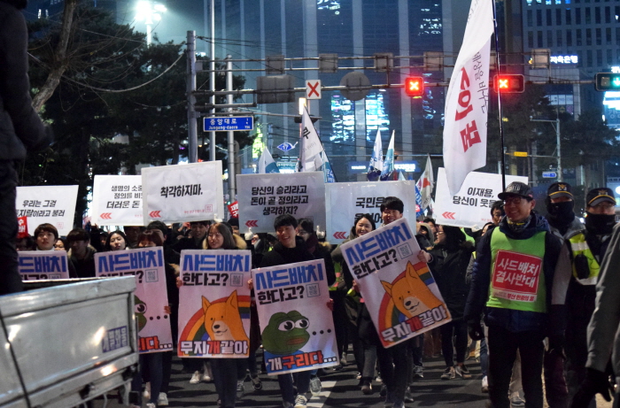 12차 부산시국대회 참가자들이 사드배치 반대와 이재용을 비판하는 피켓을 들고 행진하고 있다. 
