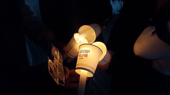 지난 12월 29일, 부천역 광장에서 열린 박근혜 하야 촉구 집회에서 참가자들이 꺼지는 촛불을 서로 붙여주고 있는 장면