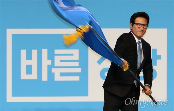 24일 오후 서울 송파구 올림픽공원 올림픽홀에서 열린 바른정당 중앙당 창당대회에서 정병국 대표가 당기를 흔들고 있다. 