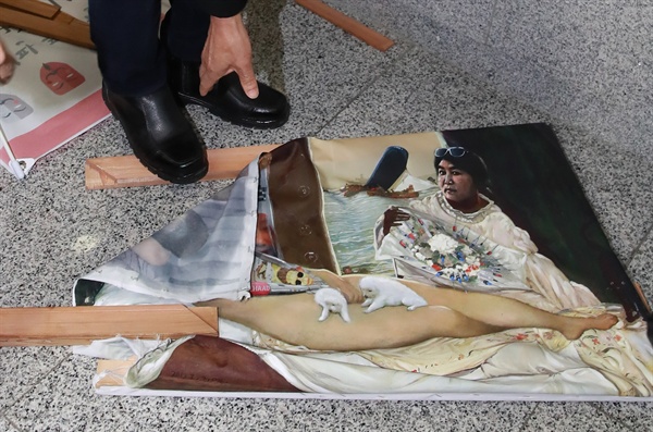 한 보수성향의 시민이 지난 24일 오후 서울 여의도 국회 의원회관 로비에서 박근혜 대통령을 나체 상태로 풍자한 그림을 부수고 있다.