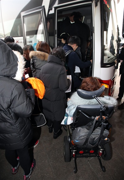 설 연휴를 앞둔 26일 오후 서초구 서울 고속버스터미널에서 '교통약자 이동편의 증진법 개정을 위한 설맞이 버스 타기 및 선물 나누기 기자회견'을 마친 전국장애인차별철폐연대 관계자들이 버스에 타는 시민들을 바라보고 있다.