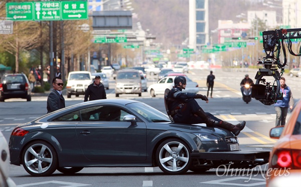 크리스 에반스, 세상에서 가장 편한 촬영자세(?) 4일 오전 서울 상암동 DMC 월드컵북로에서 촬영된 <어벤져스2> 촬영 도중 '캡틴 아메리카' 복장을 한 할리우드 스타 크리스 에반스가 승용타 보닛에 걸터 앉아 도로를 왔다갔다하며 촬영을 하고 있다.