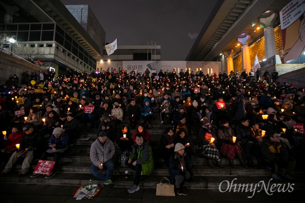   4일 오후 서울 종로구 광화문광장에서 열린 '2월에는 탄핵하라-14차 범국민행동의 날' 집회에 참가한 시민들이 세종문화예술회관 계단에서 촛불을 밝히고 있다.