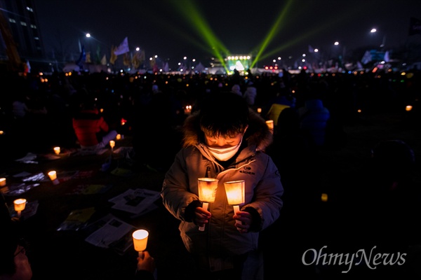  4일 오후 서울 종로구 광화문광장에서 열린 '2월에는 탄핵하라-14차 범국민행동의 날' 집회에 참가한 시민들이 촛불을 밝히고 있다.