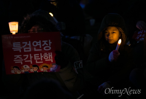 지난 4일 오후 서울 종로구 광화문광장에서 열린 '2월에는 탄핵하라-14차 범국민행동의 날' 집회에 부모님과 함께 참가한 어린이가 촛불을 밝히고 있다.