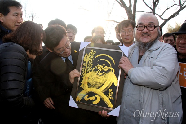 더불어민주당 대통령 경선후보인 이재명 성남시장이 5일 오후 김해 봉하마을 고 노무현 전 대통령 묘소를 참배하기에 앞서 한 스님으로부터 달마도를 선물로 받고 있다.